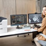 Donna in un ufficio accanto alla stampante Xerox® VersaLink® C620